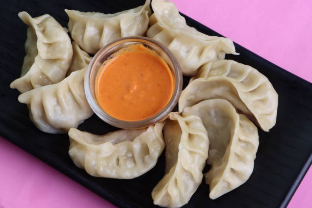 istock Traditional dumpling momos food from Nepal served with sesame chutney, Selective focus 1450236399