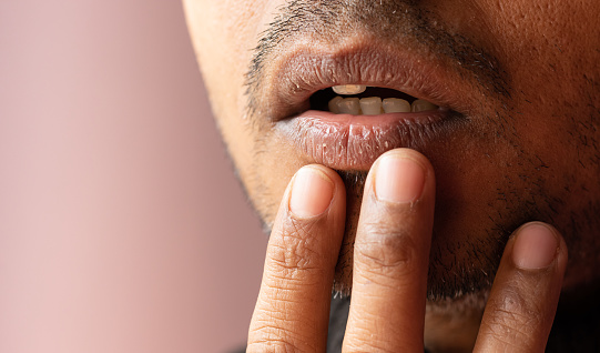 Close up of dry lips of an Indian male checking with fingers