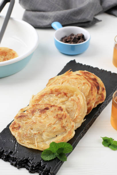 Roti Canai or Paratha Parotta Flat Bread, Also Known as Roti Maryam in Indonesia. Roti Canai or Paratha Parotta Flat Bread, Also Known as Roti Maryam in Indonesia. Can Served with Curry or Sweet Topping roti canai stock pictures, royalty-free photos & images