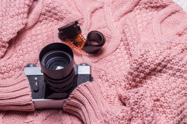 istock An old retro camera lies on a pink wool sweater 1450247191