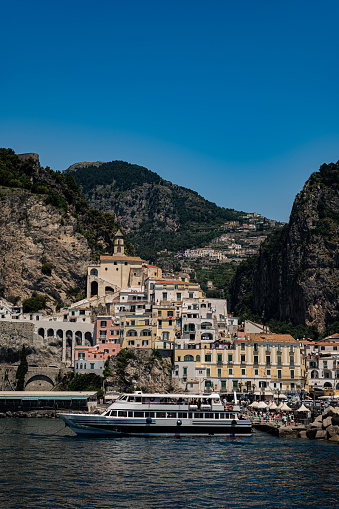 View of the Amalfi coast from the sea. View of the rocks, green mountains and small towns from the boat. Summer holidays in the south of Italy, European holidays