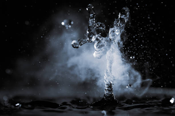 istock Boiling water splash with steam on black background closeup 1450249036