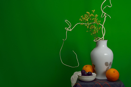 Still Life Fruits were placed on the timber with a beautiful vase of flowers.