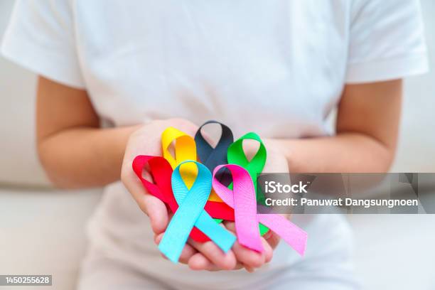 World Cancer Day February 4 Hand Holding Blue Red Green Pink Black And Yellow Ribbons For Supporting People Living And Illness Healthcare And Autism Awareness Day Concept Stock Photo - Download Image Now