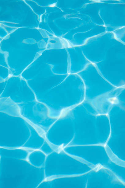 istock Background, blue water waves in the pool with sun reflection. Selective focus 1450257691