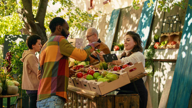 bäuerin gibt kunden kostenlose apfelproben zur verkostung von speisen - farmers market stock-fotos und bilder