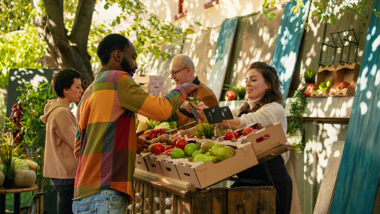 Una agricultora da muestras gratuitas de manzanas a los clientes para la degustación de alimentos photo