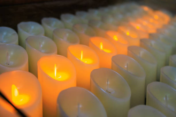 istock Modern electronic candles imitating classic wax candles in a dark temple. Blurred background with selective focus 1450258009
