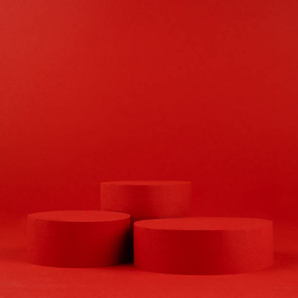 istock Festive elegant saturated red stage with two cylinder podiums on table for presentation cosmetic products, gifts, goods in luxury modern style, copy space, square. Template for advertising, design. 1450259361