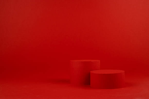 istock Rich red festive stage mockup with two cylinder podiums on table for presentation cosmetic products, gifts, goods in elegant modern minimalist style, copy space. Template for advertising, design. 1450259459