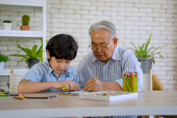 istock Grandson is drawing with grandfather. 1450260638