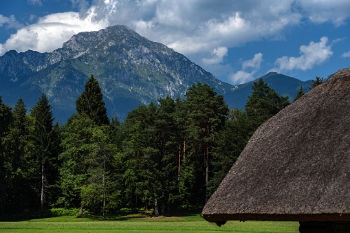 VView of Mount Storžič over the roofs of haystacks covered with straw,Gorenjska,Slovenija,Europe