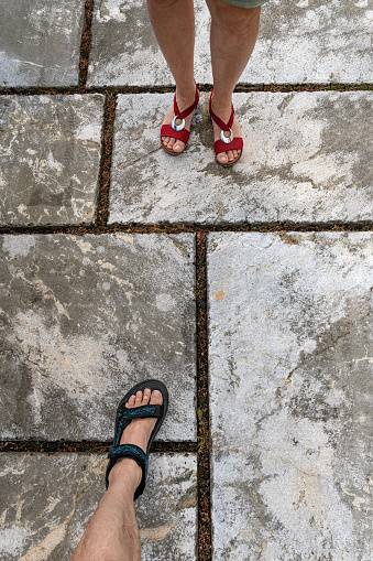 Feet of a husband and wife meeting on the cobbled floor, Gorenjska, Slovenia