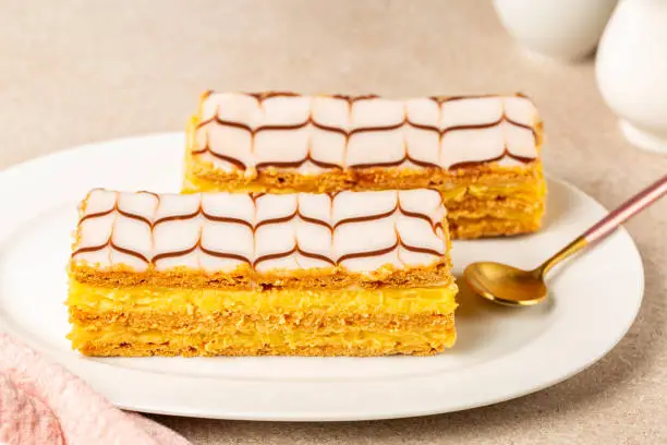 The mille-feuille, or millefeuille, is a piece of French pastry made from three layers of puff pastry and two layers of pastry cream. The top of dessert is iced with icing sugar.