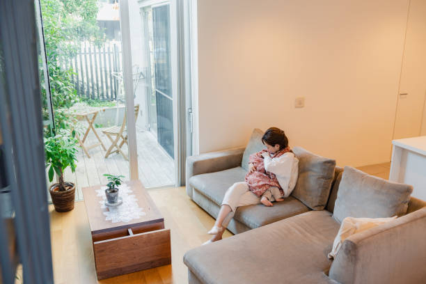 istock A mother breastfeeding her baby on the sofa 1450265241