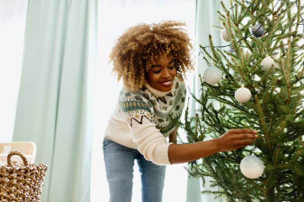 istock Beautiful woman decorating a Christmas tree 1450268538