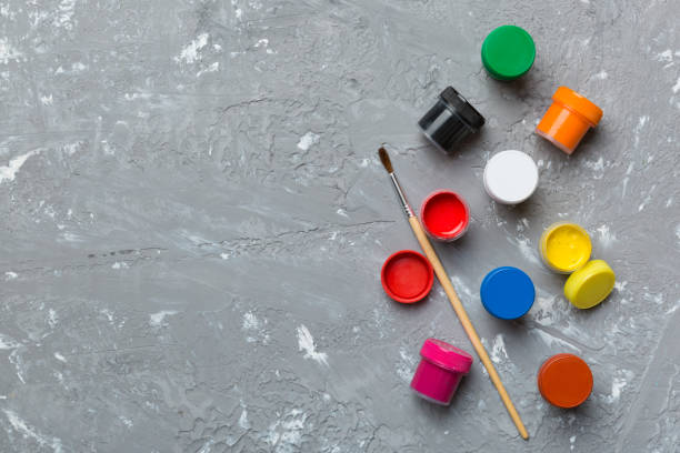 istock art palette with paint and brushes, close up. Top view with empty space. workplace for creativity. home teaching concept drawing 1450270381