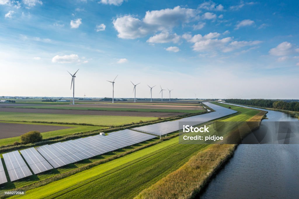 Wind, sun and water energy. Solar panels and wind turbines generating renewable energy for green and sustainable future. Sustainable Resources Stock Photo