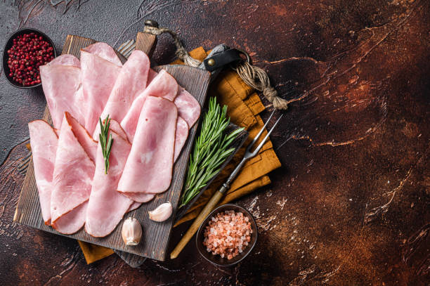 istock Flat slices of square sandwich ham with herbs. Dark background. Top view. Copy space 1450272306