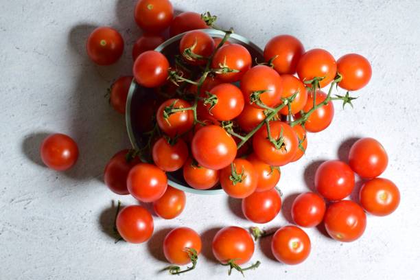 istock Top view of plump juicy cherry tomatoes on a bowl on stone surface 1450272449