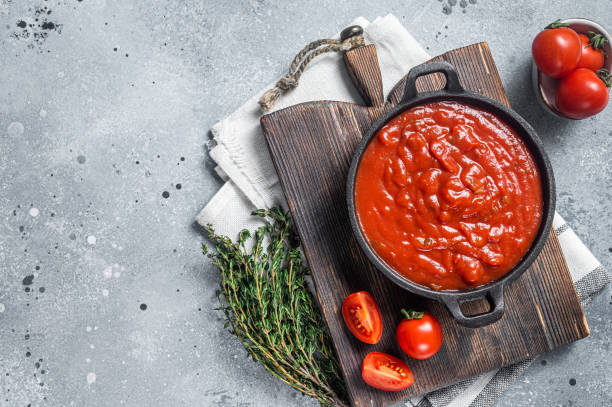 istock Homemade red tomato sauce with basil in pan. Gray background. Top view. Copy space 1450273713