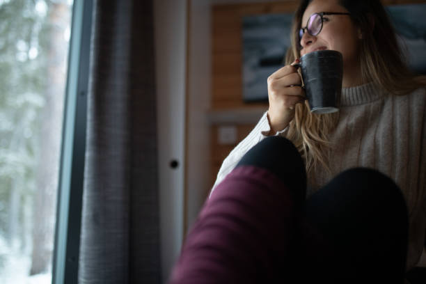 istock Smiling woman drinking tea and enjoying winter magic indoors 1450274699