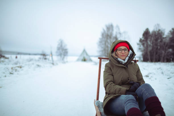 istock A woman dressed in winter clothes is getting ready for sledding 1450274750