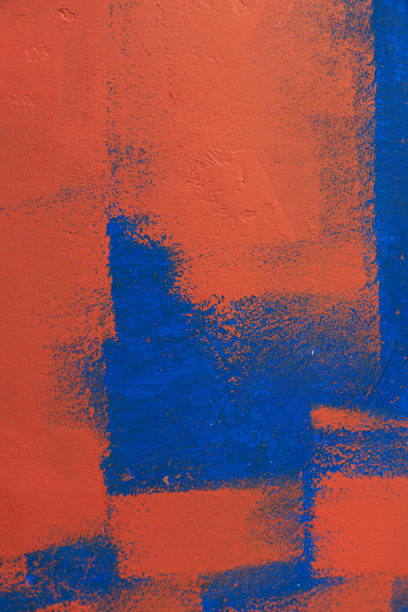 Red paint applied unequally with paint roller on blue background, abstract backgrounds