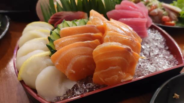 istock Salmon and scallop sashimi and blurred background. 1450280114