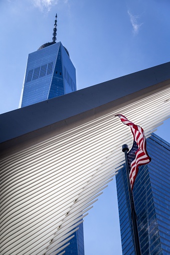 New York City, United States – August 23, 2019: One WTC Tower and the World Trade Centre Station building above a USA flag.