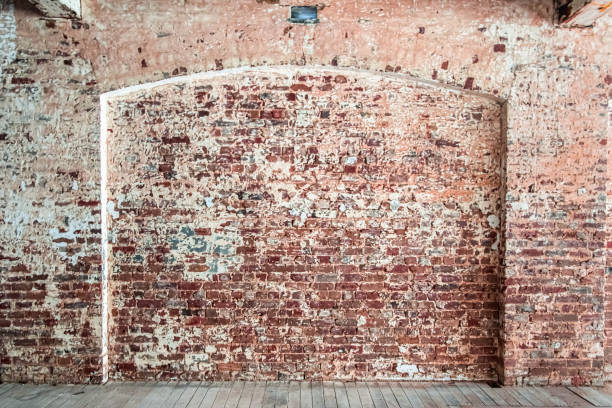 muro di mattoni alterato e angosciato con caratteristica ad arco in un magazzino con pavimento in legno - architecture feature foto e immagini stock