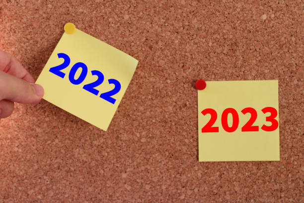 istock a man's hand pulling out a sticky note. year change from 2022 to 2023. 1450285333