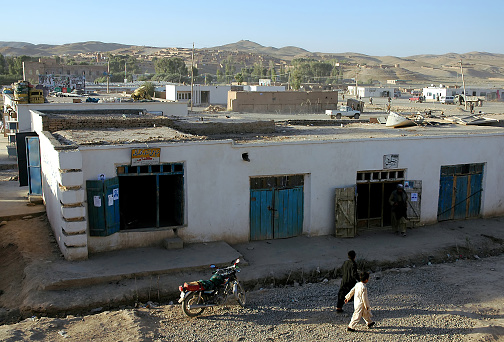 Chaghcharan, Ghor Province / Afghanistan: A view over Chaghcharan, one of the largest towns in a remote part of Central Afghanistan. A local life scene of people walking in the street.