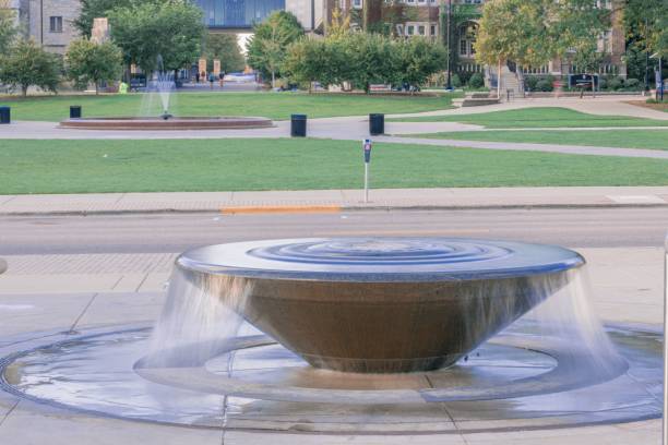 istock Fountain in front of a green lawn and a building 1450292479