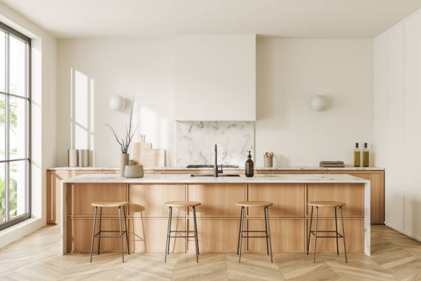 istock Light kitchen interior with bar countertop and seats, cooking space and window 1450293829