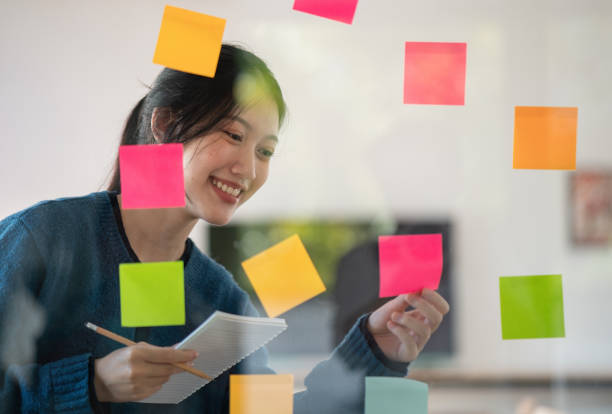 istock Young confident Businesswoman planning with adhesive notes in creative office. 1450294952