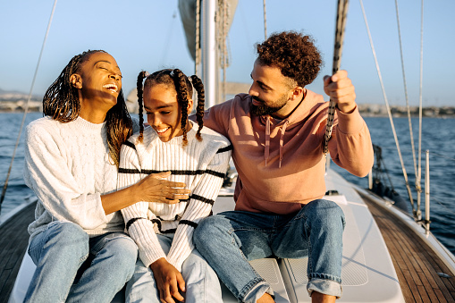 Happy young family enjoying their vacation on the yacht