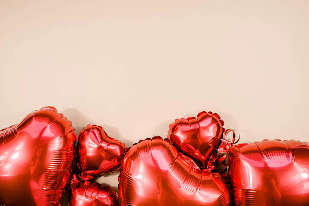 istock Text frame with red hearts foil balloons upper view on beige Valentines Day background. Copyspace. 1450298648