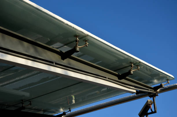 istock bus stop glazing. glass canopy attached at n several points to the metal structure. Gaps between the sky that have dots as protection against sunlight, snow covered, frosted tempered glass 1450303293