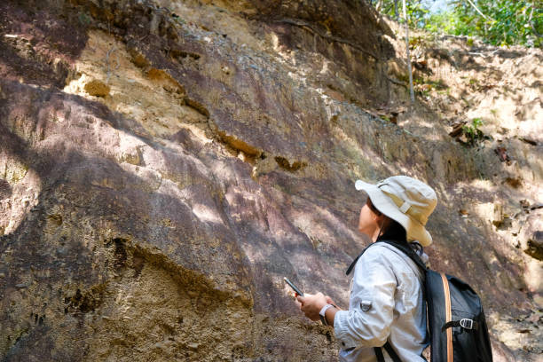 istock Female geologist with backpack exploring nature trail in forest and analyzing rock or gravel. Researchers collect samples of biological materials. Environmental and ecology research. 1450303910
