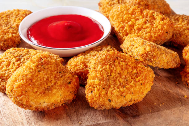 istock Chicken nuggets with ketchup close-up on a wooden board 1450304568