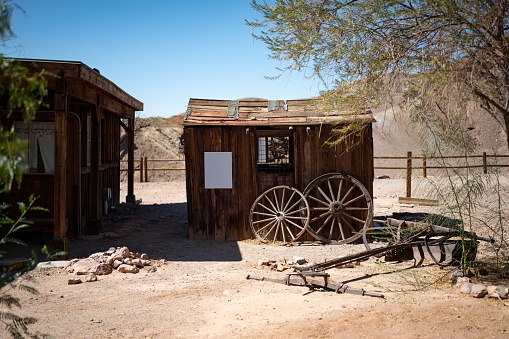 Yermo, United States – August 04, 2022: A wooden shed with some wagon wheels leaning on it in the abandoned town of the far west