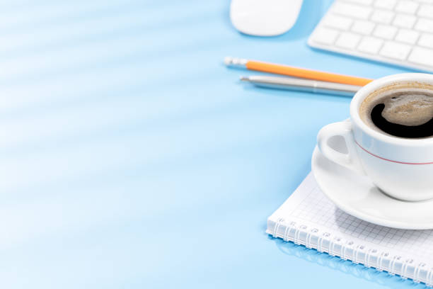 Top view business office desk with keyboard, office supplies and coffee. Workspace with sunny light and copy space