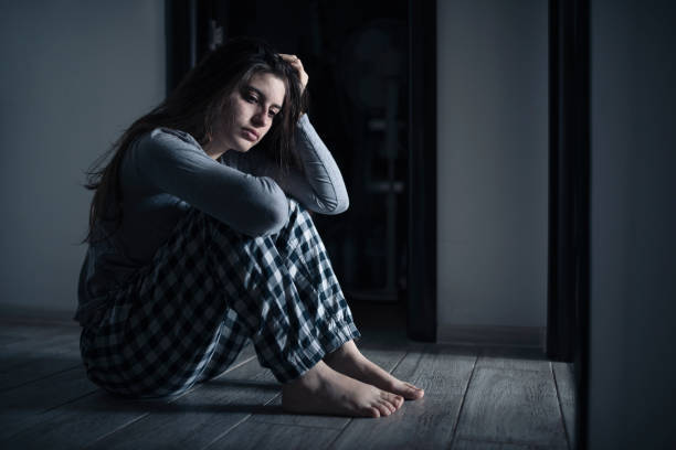 istock Depressed woman sitting on the ground. 1450308639