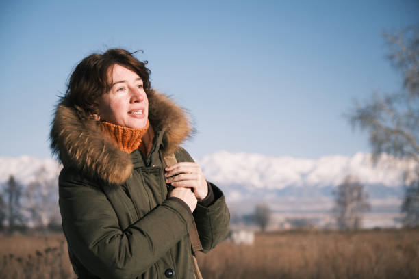 istock Woman walking on winter road is looking at view 1450309883