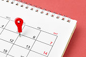 The Embroidered red pins on a blank calendar on the Friday 13th with selective focus on red background.
