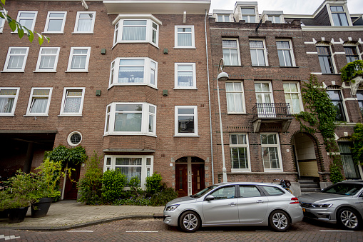 Amsterdam, Netherlands – June 10, 2021: Residential homes in capital city Amsterdam with exterior facade and typical Dutch style