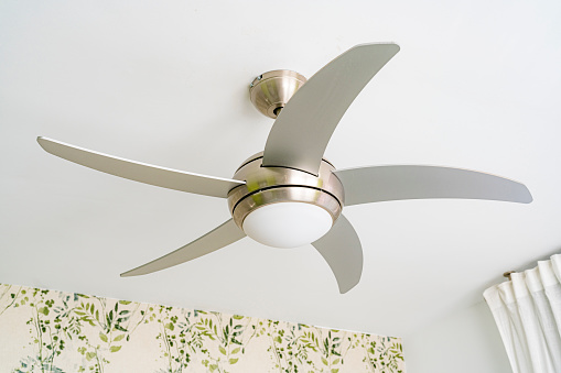 Metal fan with light hanging from white ceiling of a bedroom. High resolution 42Mp indoors digital capture taken with SONY A7rII and Zeiss Batis 40mm F2.0 CF lens