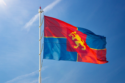 Krasnoyarsk flag against a blue sky waving on the wind. Wind fluttering the flag of Krasnoyarsk
