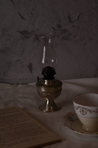 istock photo kerosene lamp with a book and an empty cup 1450321695